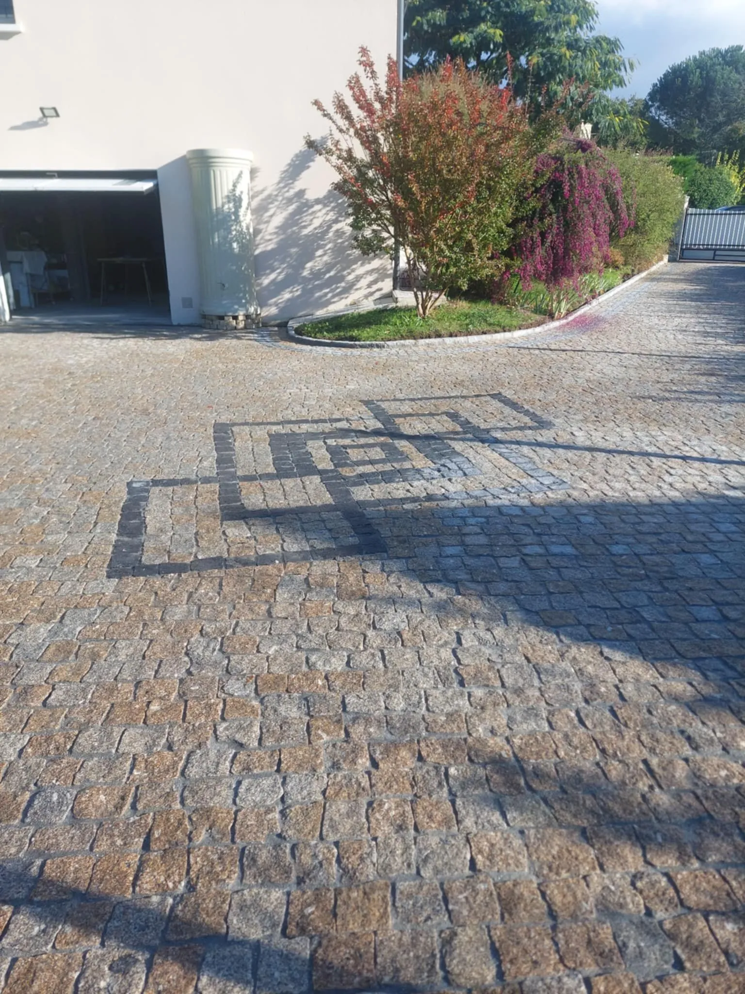 Pavage granit avec motif géométrique en granit gris devant une maison contemporaine